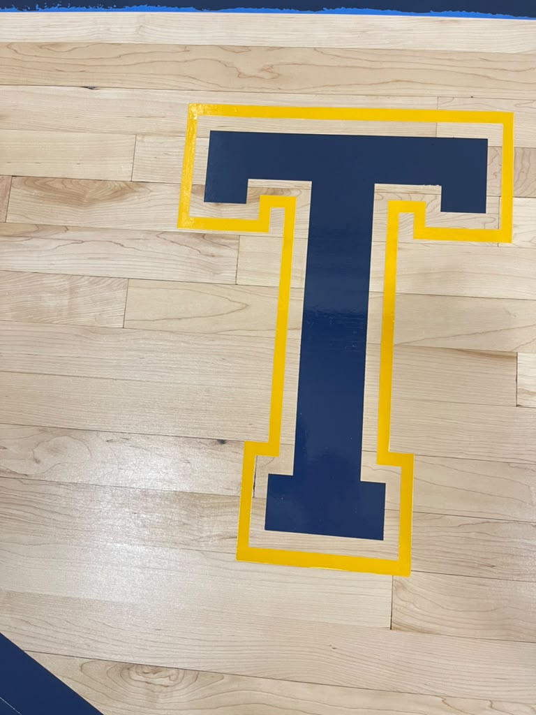 Hand-painted navy and gold T center-court logo